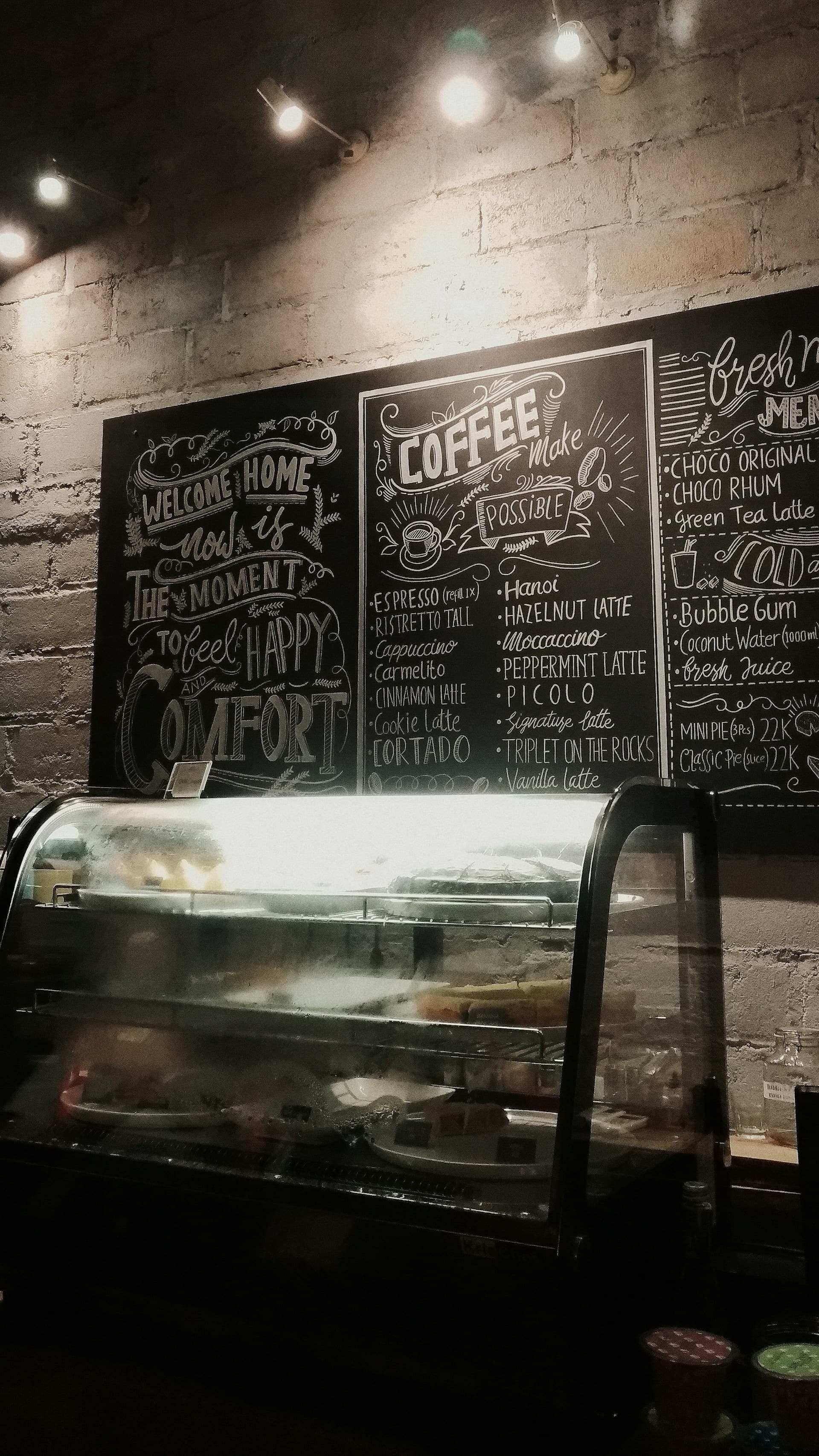 Interior coffee shop with hand-lettered chalk menu boards covering the back wall.
